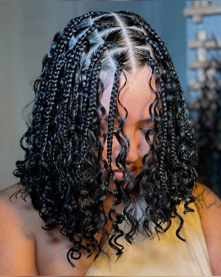 Shoulder-length box braids with a centre part and curly ends