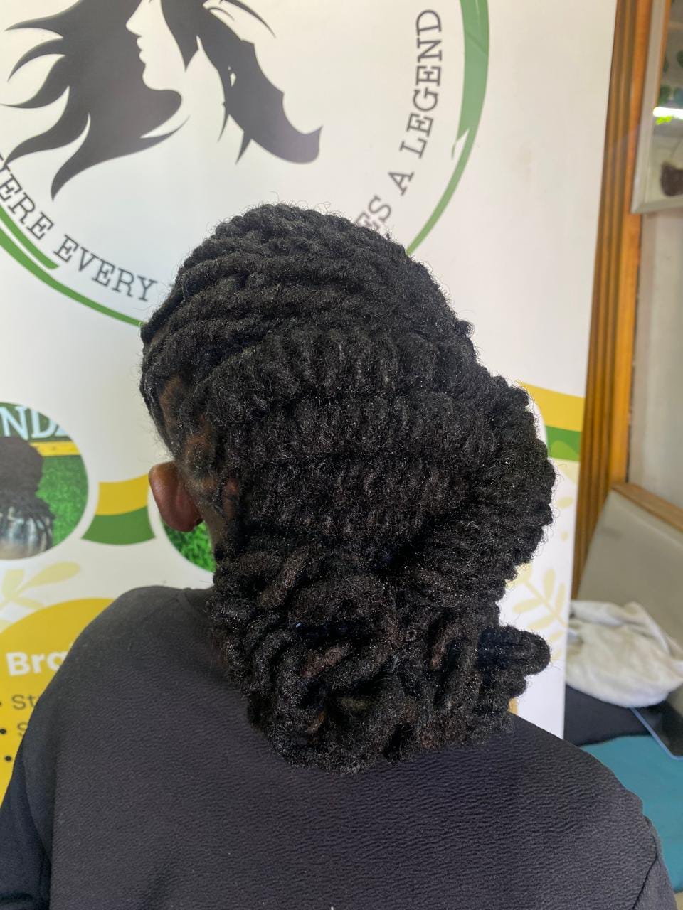 Back view of locs twisted and rolled into a low updo