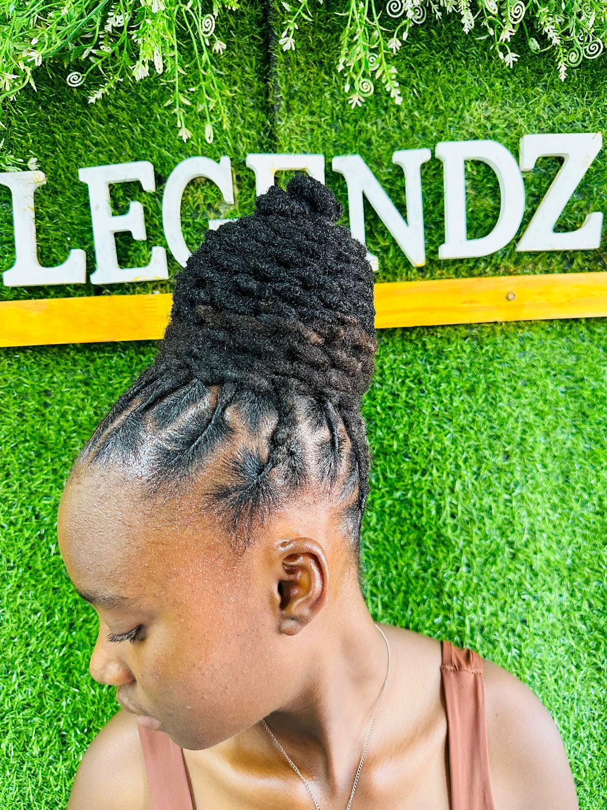 Locs twisted up from the hairline into a high bun